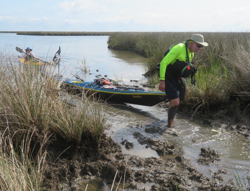 Greg portaging his kayak through the mud