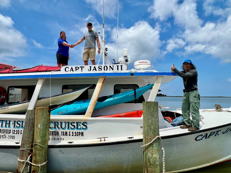 Jessica and Greg shaking hands on top of the power boat with me on the side