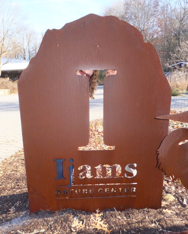 Norma and Carmen looking through the 'I' in the nature center sign