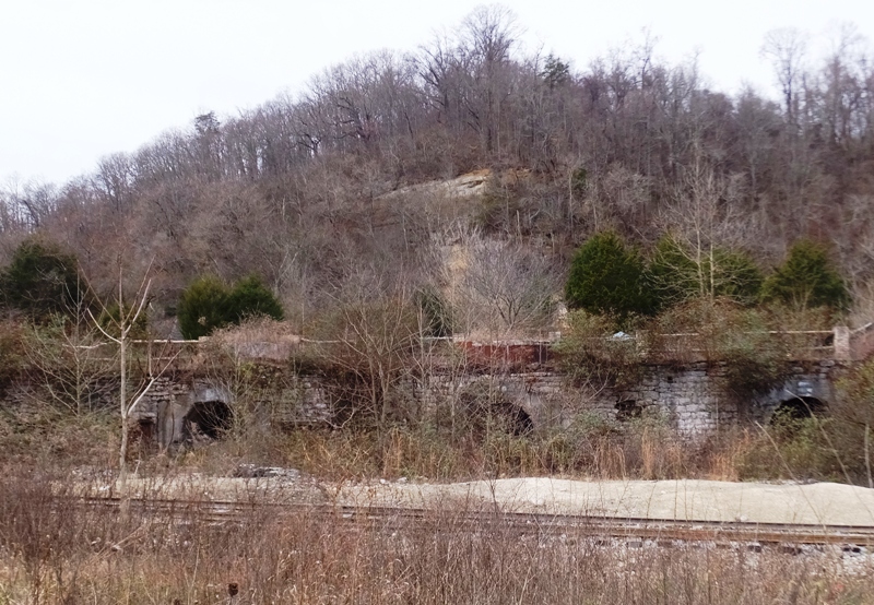 Lime kilns in front of hill and behind a railroad track