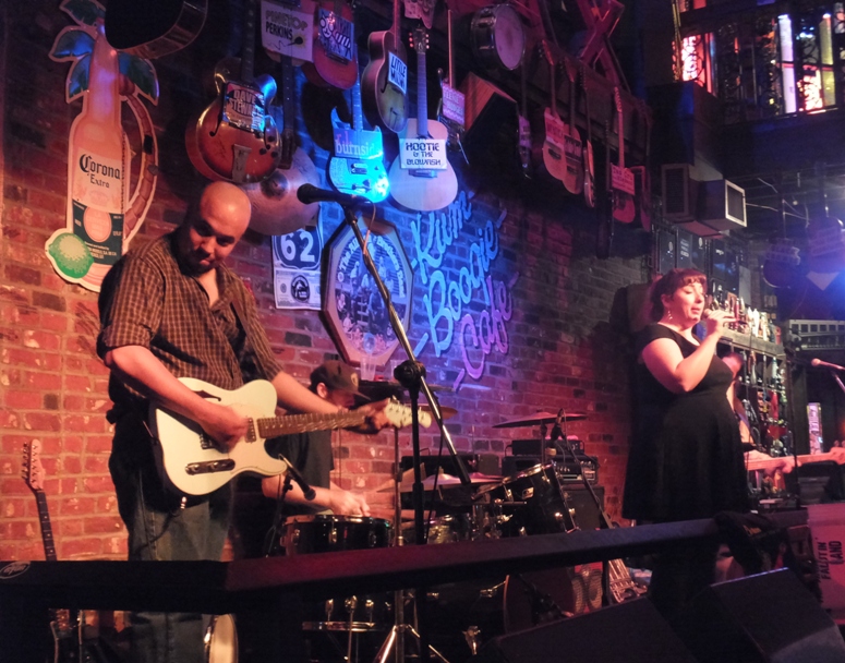 The High Falutin' Band playing with brick wall behind displaying lots of guitars