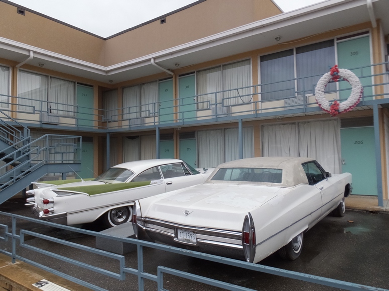 Two old cars parked outside of Lorraine Motel