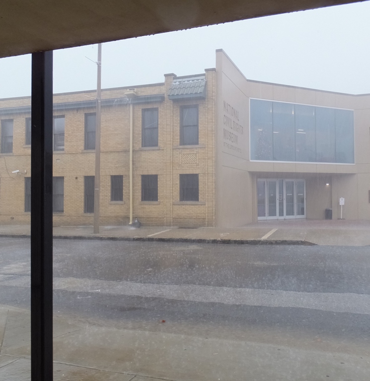 Heavy rain with water flowing over gutters of National Civil Rights Museum