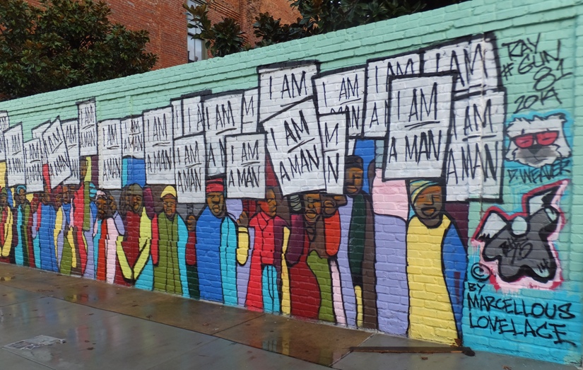 Street art of black men holding signs that read 'I am a man.'