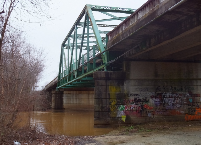 Hatchie River under bridge with graffiti-covered base