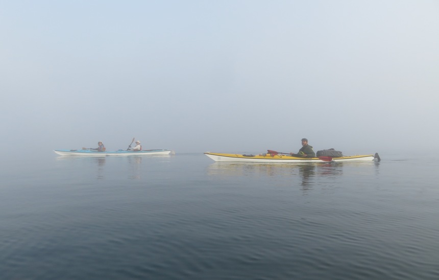 Noah, Chris, and Dorota in their kayaks, seen through the fog