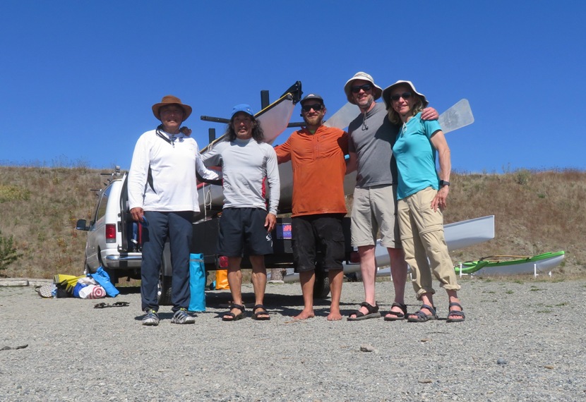 Group photo in front of loaded boat and van