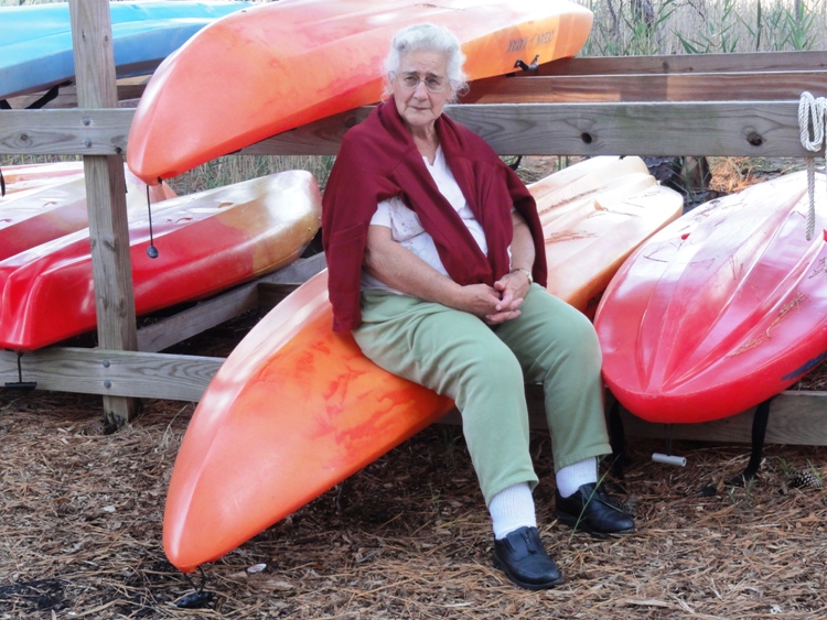 Hazel sitting on a stowed kayak