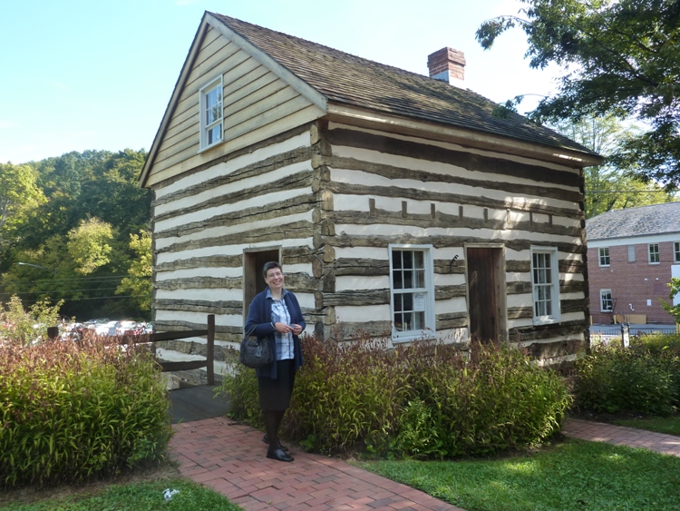 Angelika in front of log cabin