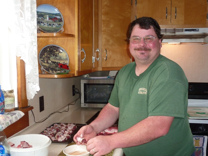 Scott making bacon wrapped venison in kitchen