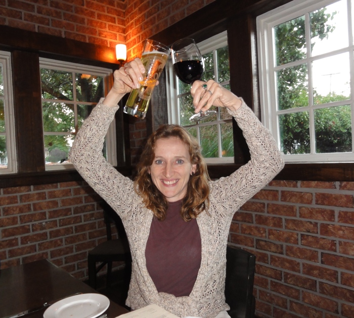 Norma with arms raised, a drink in each hand