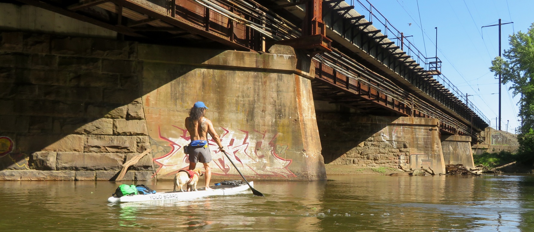 Daphne and I on SUP with train bridge in background