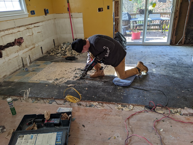 Sheldon using tool to remove old flooring