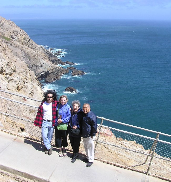 The four of us at a fence with the ocean behind