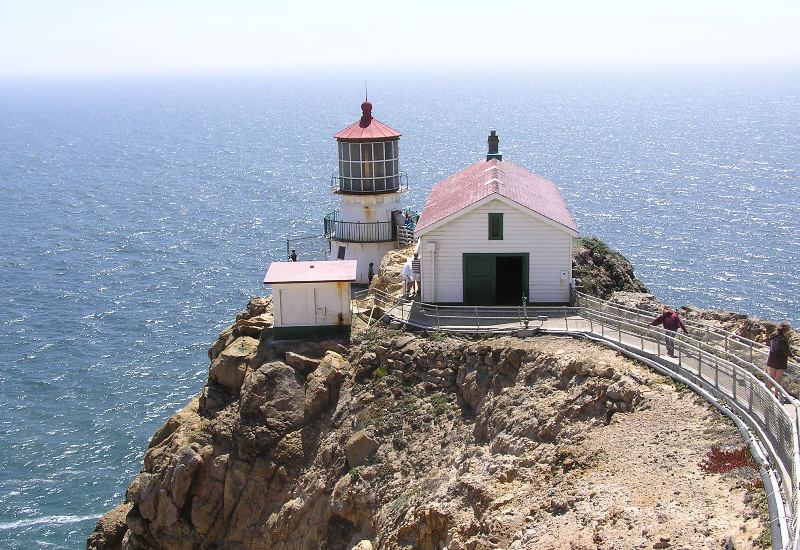 The lighthouse with steps leading to it and ocean behind