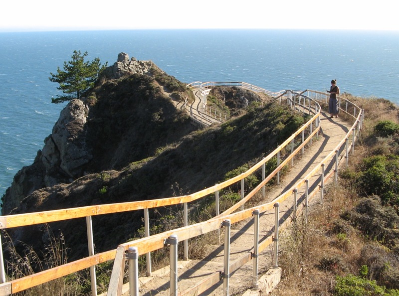 Trail leading to small rocky peak above the ocean