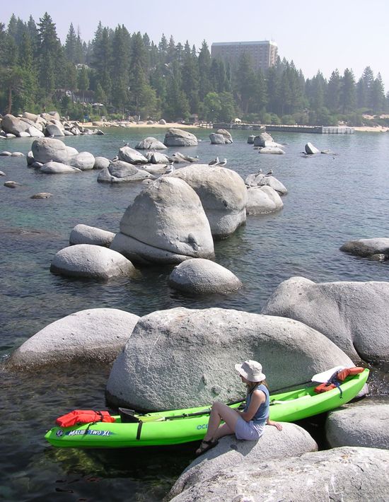 Norma sitting on a rock in the lake next to our kayak