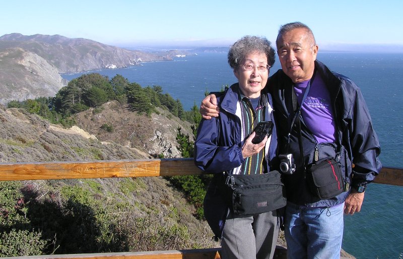 Mom and Dad smiling with the ocean behind