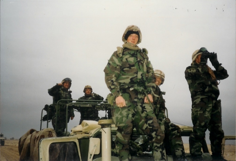 Marines in green chemical protective suits on a Humvee