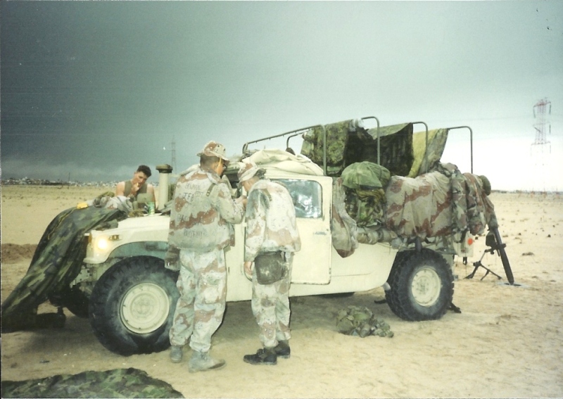 Messy Humvee loaded with gear and Marines around it