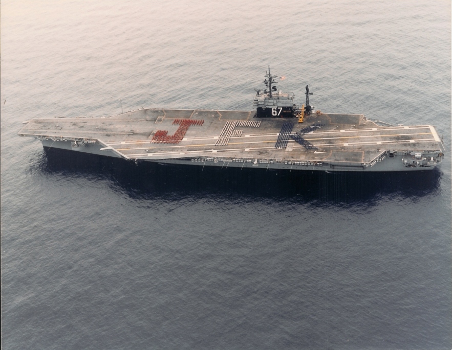 Hundreds of us on the flight deck wearing shirts to spell out 'JFK'