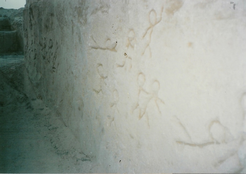 Stick figures carved in sand