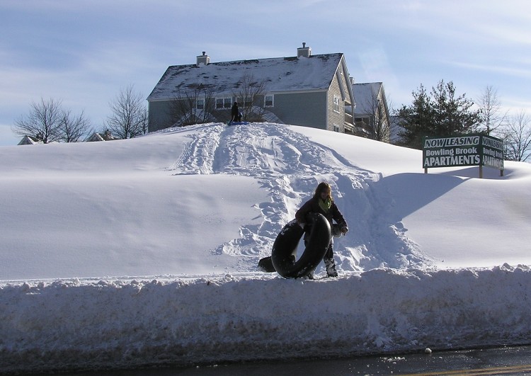 Person carrying tube in front of apartment complex hill