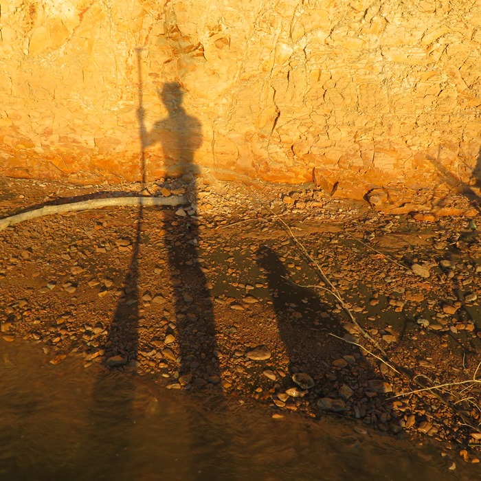 Long shadows from Daphne and me fall on Big Island cliff