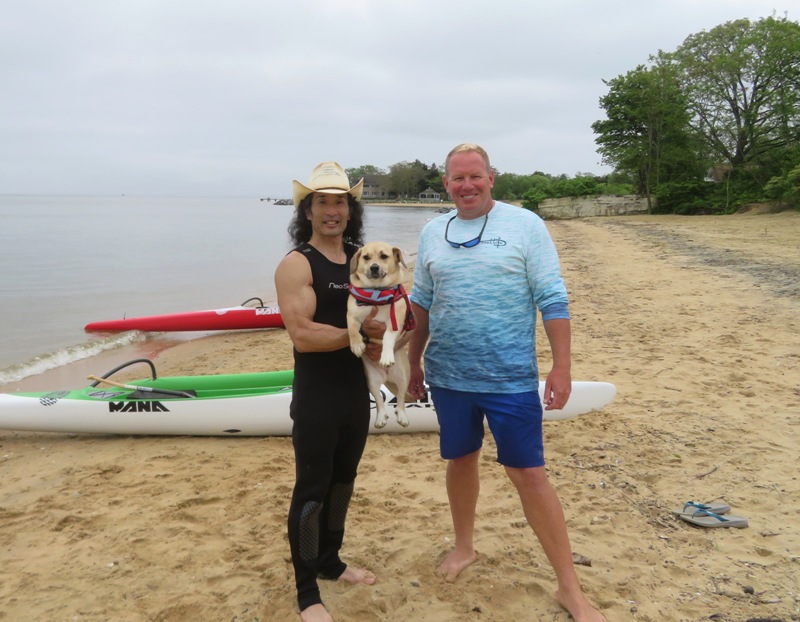 Neil, Daphne, and me on a beach with outrigger canoes in the background