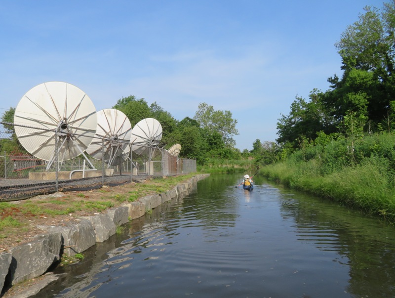 Norma kayaking past satellite dishes