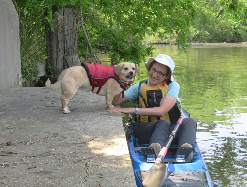 Daphne on concrete extension of bridge with Norma on kayak