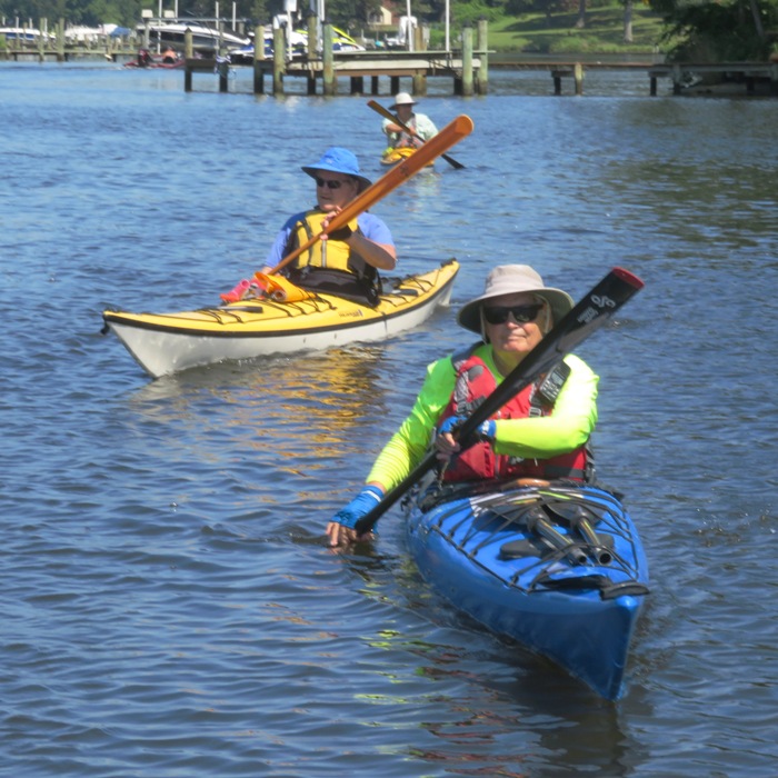 Three kayakers with John S. paddling in front