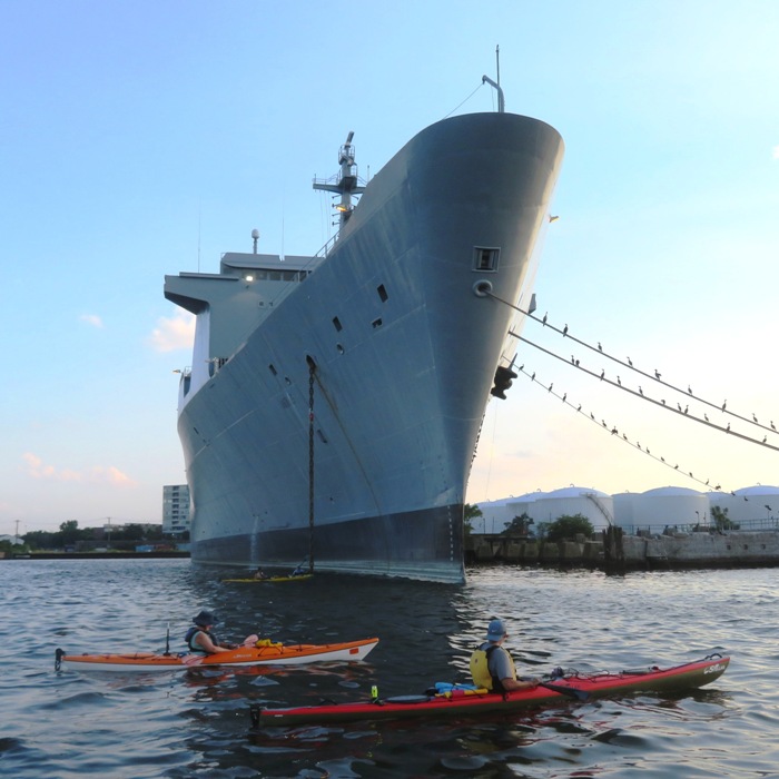 Kayakers in front of big ship