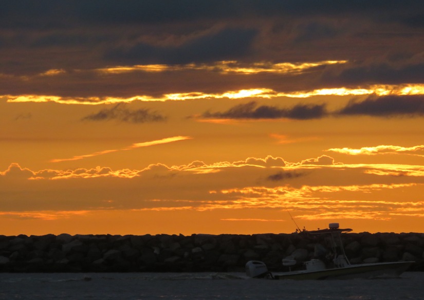 Power boat with the early morning sun illuminating the clouds