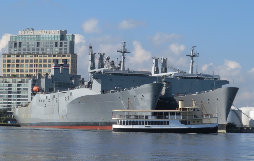 Small boat in front of the USNS Denebola and the USNS Antares