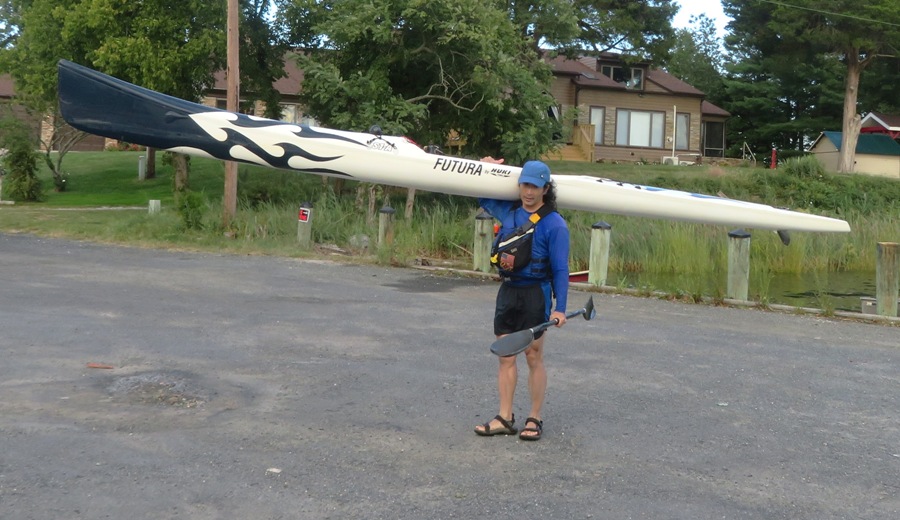 Me holding my surf ski over my shoulder