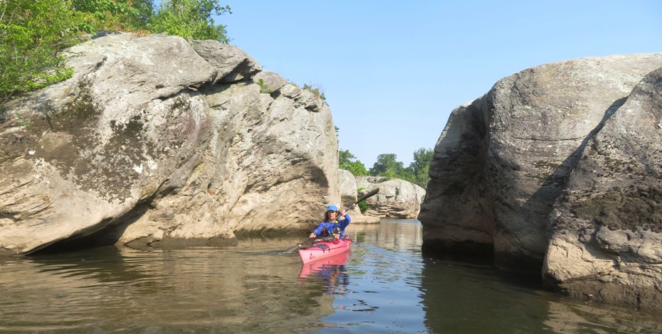 Me kayaking between two big rocks