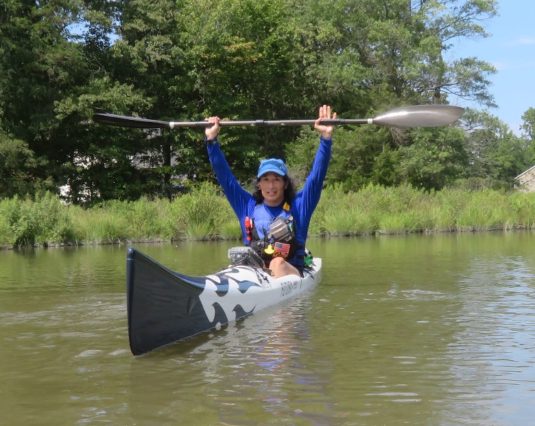 Me on surf ski with paddle above head