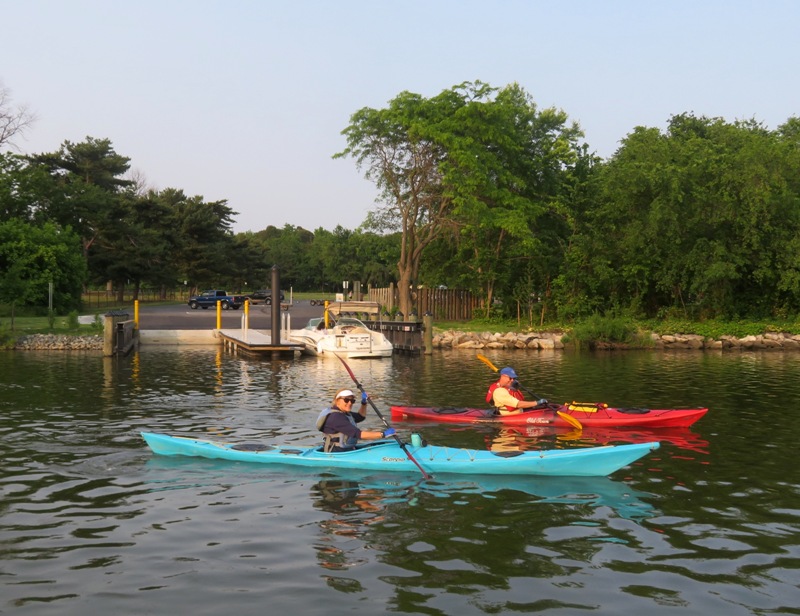 Two kayakers in front of double paved boat ramp