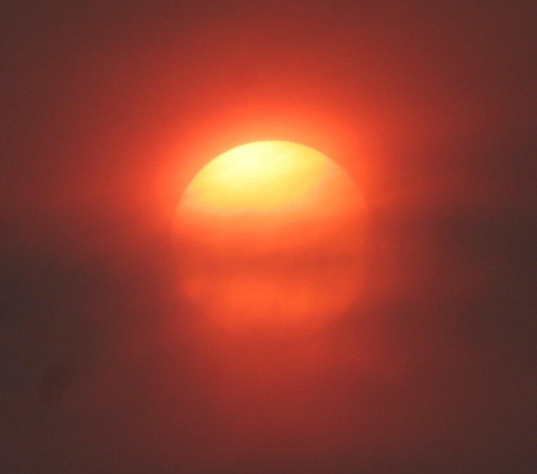 Sun wearing a reddish-orange halo