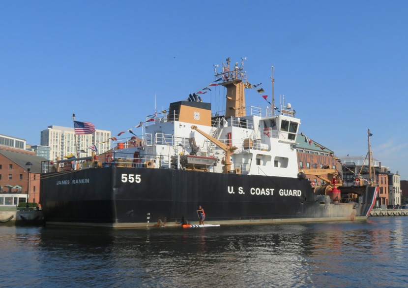 Ellison paddling in front of the James Rankin Coast Guard buoy tender