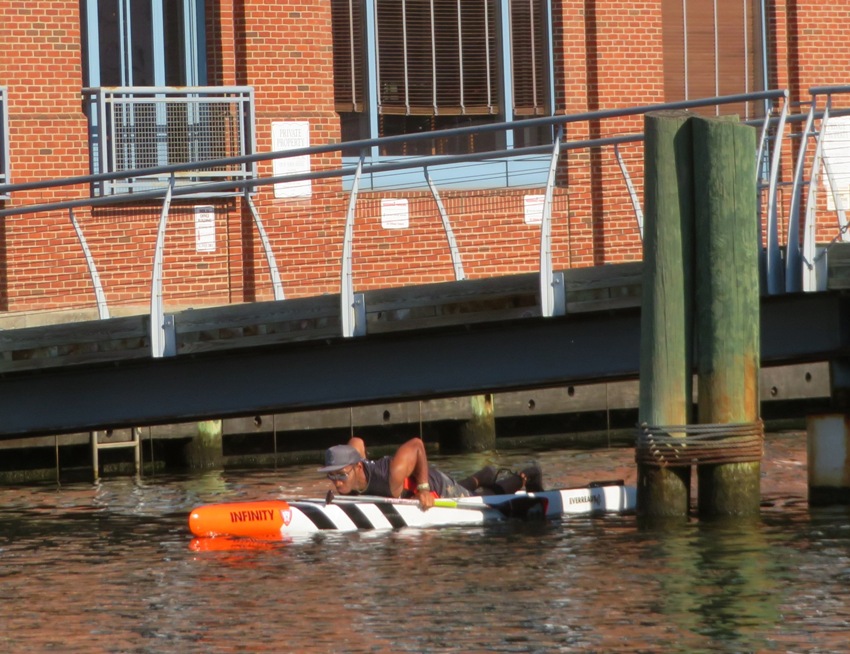 Ellison prone on his SUP going under bridge