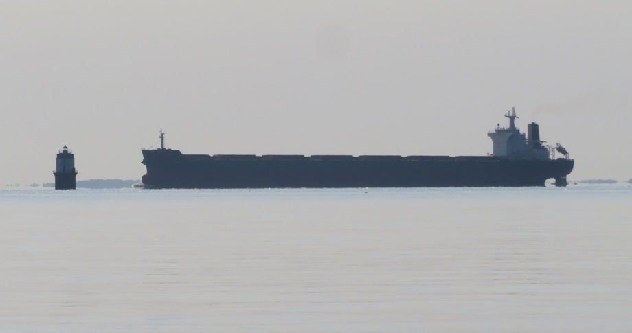 Lighthouse and cargo ship