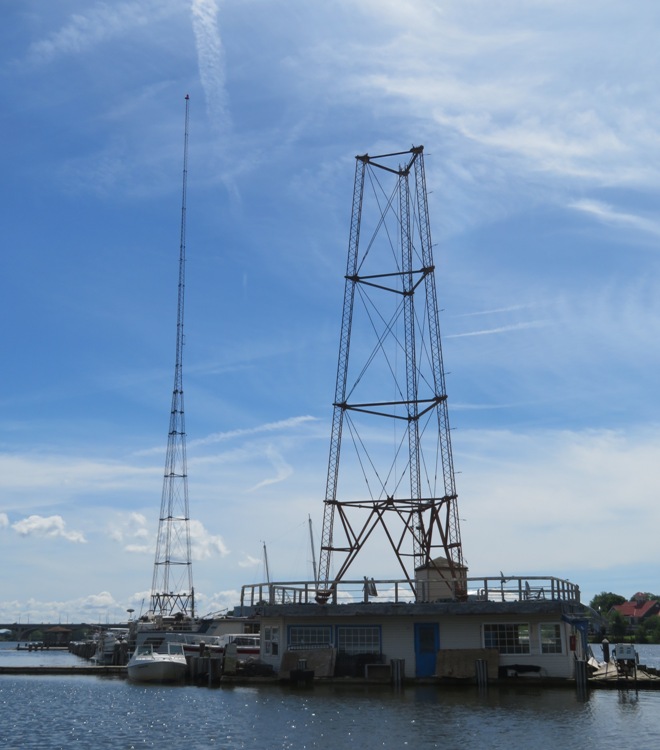 A full radio tower and one where the top half broke off or was removed